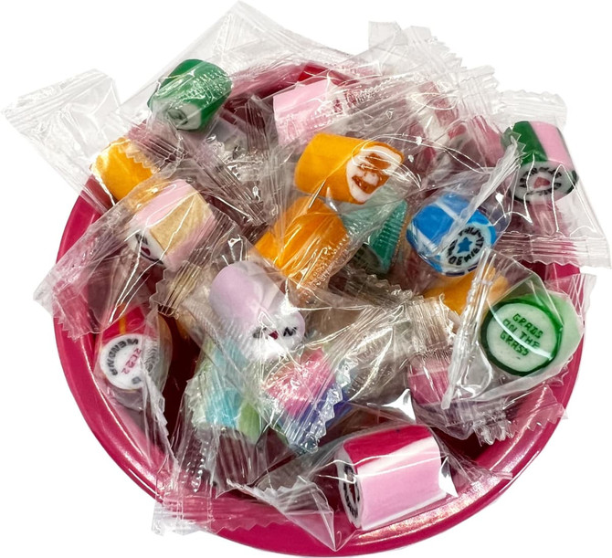 A bowl filled with individually wrapped rock candies in various colours, including pink, yellow, green, and orange.