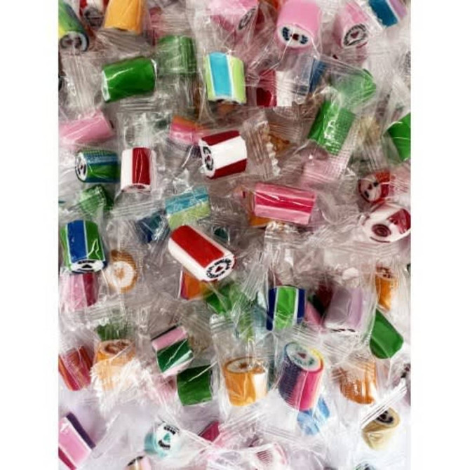 Individually wrapped rock candy in various colours, including pink, green, blue, and red, arranged in a large pile.