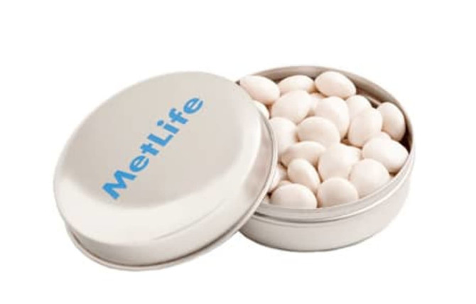 A silver tin containing white chewy mints, featuring a logo on the lid.