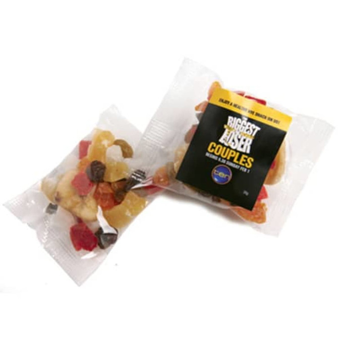 Dried fruit mix in a clear package, featuring colourful pieces of fruit, with a logo present on the packaging.