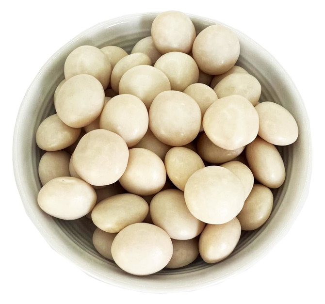 A bowl filled with pale beige, round mints, showcasing a smooth, glossy surface.
