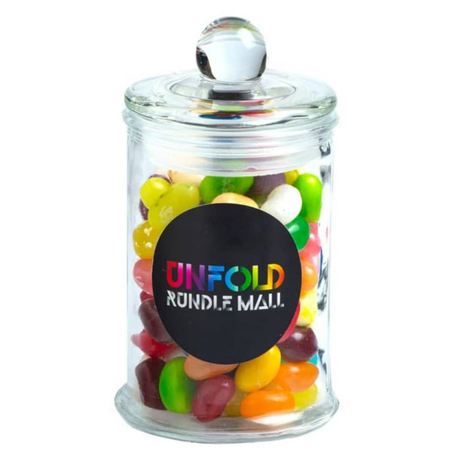 A glass apothecary jar filled with colourful jelly beans, featuring a decorative lid and a logo.