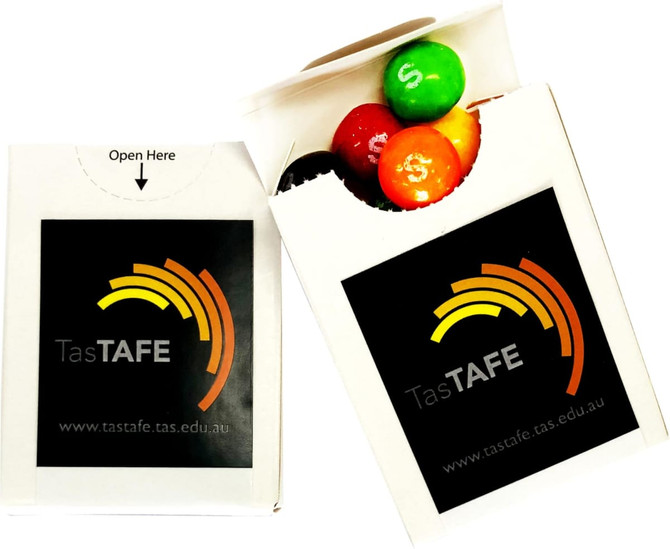 A flip lid cardboard box containing colourful Skittles in red, green, and orange, with a branded logo on the front.