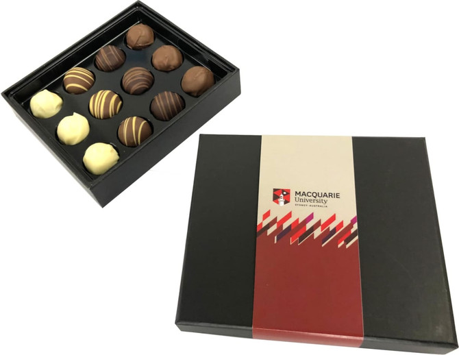 A black box containing assorted chocolate truffles in various flavours, featuring a logo on the packaging.