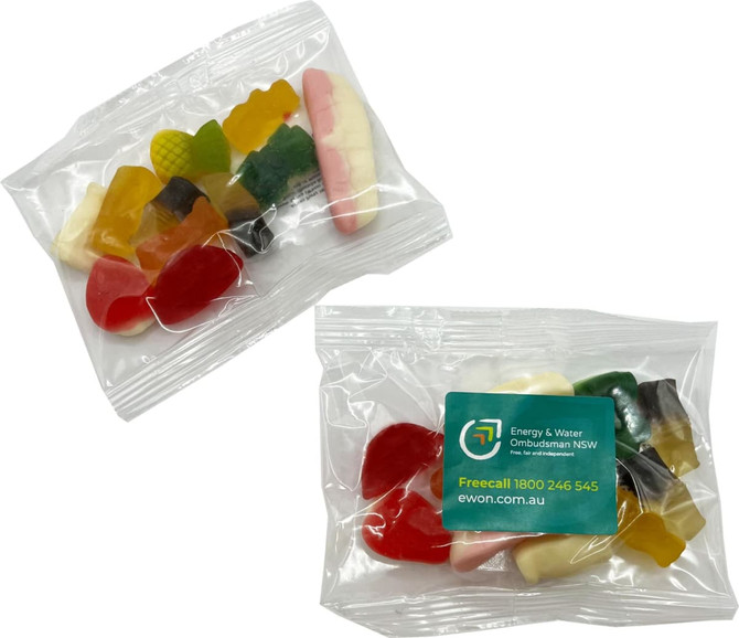 A clear bag containing various colourful mixed lollies, including red, yellow, green, and pink shapes.