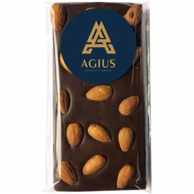 A chocolate bar featuring dark chocolate with whole almonds, wrapped in clear packaging and a logo on the front.