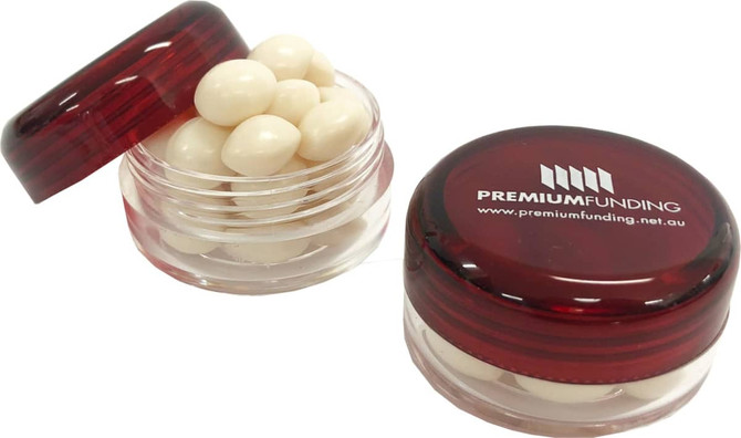 A small screw cap jar in red containing white mints, featuring a logo on the lid.