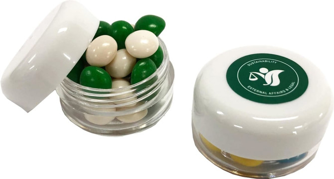 A small screw cap jar filled with green and white chewy fruit candies, featuring a branded lid.
