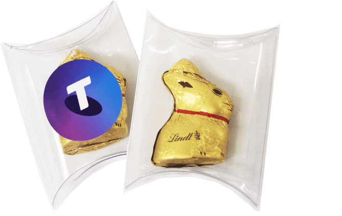 A clear pillow pack containing a gold 10g Lindt Bunny with a logo on one side and the bunny visible on the other.