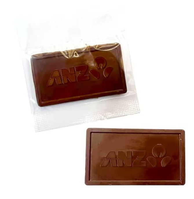 An embossed chocolate bar in dark brown, packaged in a clear wrapper, featuring a logo.