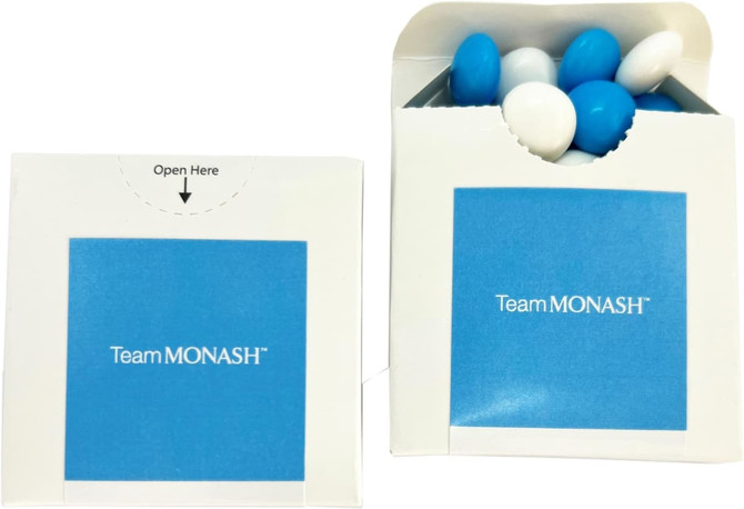 A flip lid cardboard box containing chocolate beans in blue and white. The box has a logo on the front.