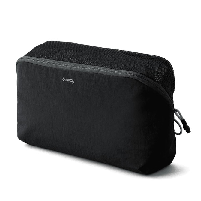 A black packing cube with a zippered mesh top, featuring branding on the front.