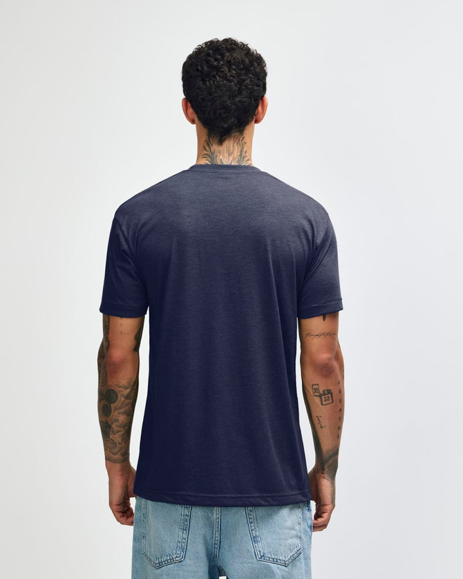 A navy American Apparel Tri-Blend T-shirt displayed from the back. The model has tattoos and wears light blue jeans.