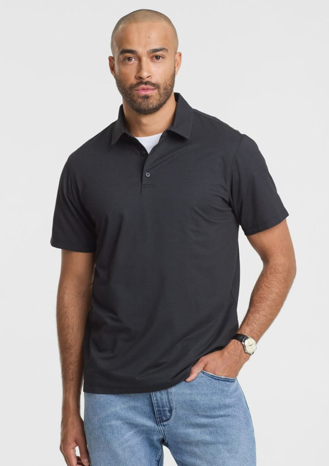 A black short sleeve polo shirt worn by a man, featuring a collar and a subtle logo.