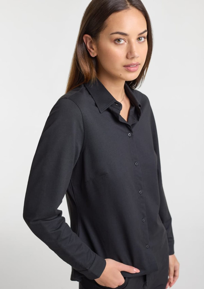 A women's long sleeve shirt in black, featuring a button-down front and a tailored fit, with a branding logo.