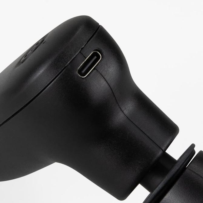 A compact handheld massager in sleek black, featuring a charging port and ergonomic design.