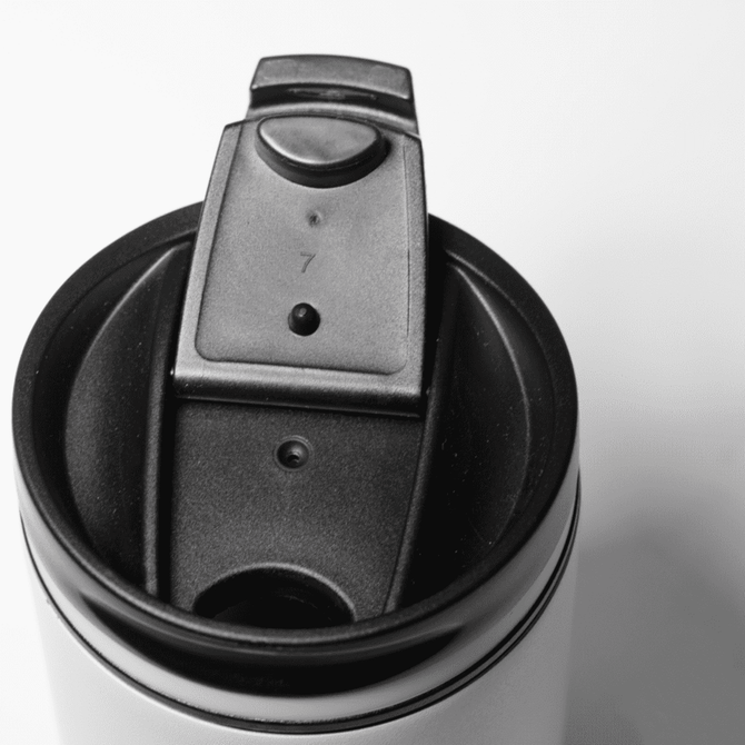 A drink bottle featuring a black lid with a secure opening mechanism, set against a white background.