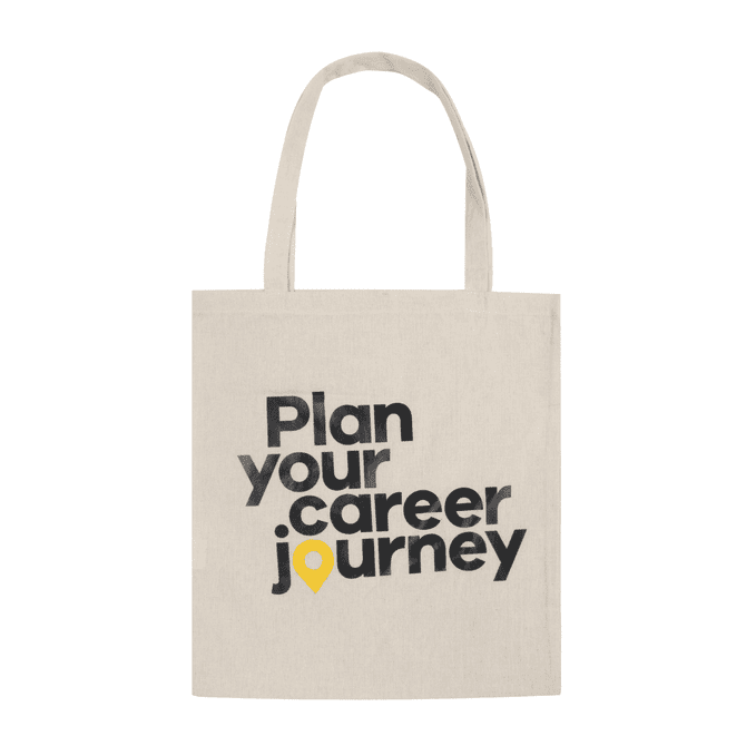 A natural-coloured tote bag with black text and a yellow marker icon. It features a logo.