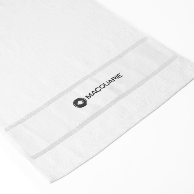 A white gym towel with a grey stripe and a logo on the edge. Ideal for leisure and fitness activities.