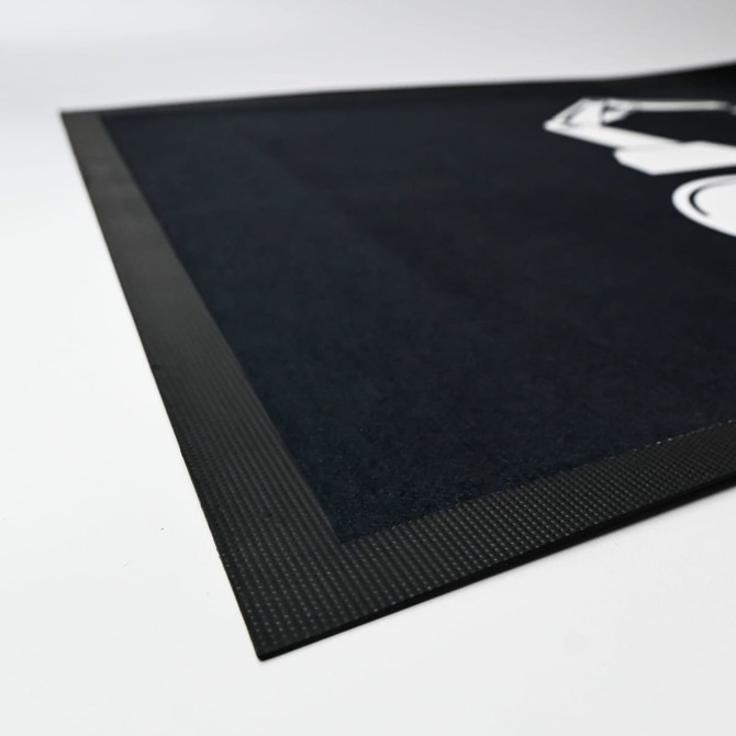 A black mat with a textured border, featuring a graphic design in a contrasting colour.