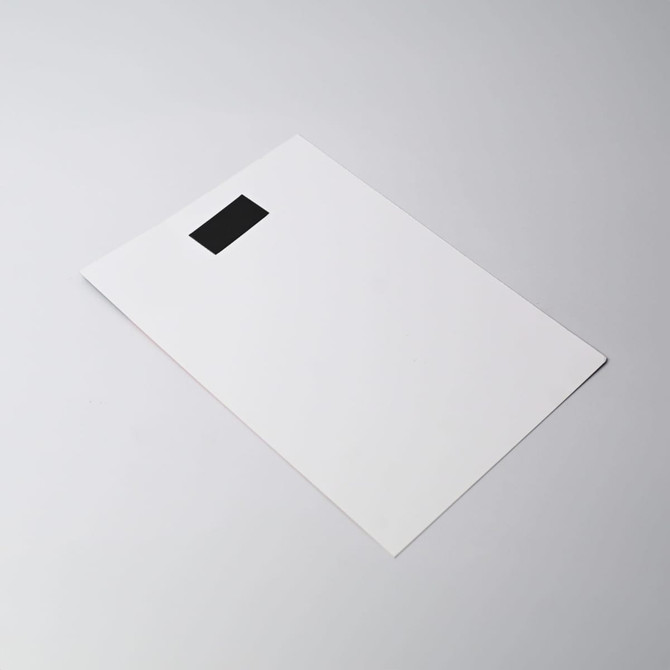 A flat, white magnetic calendar with a black tab at the top. The design is simple and minimalistic.