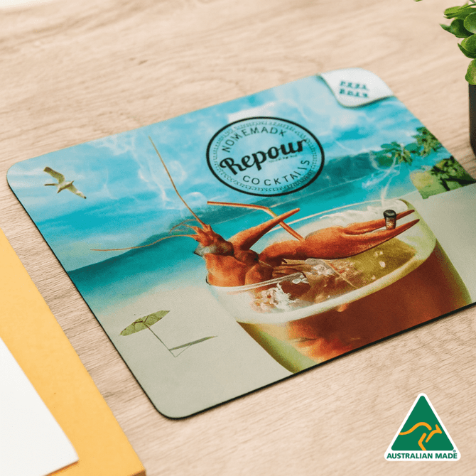 A cocktail coaster featuring a vibrant drink with shrimp, an umbrella, and a beach backdrop. Includes a logo.