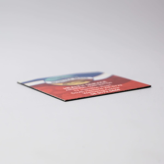 A 50mm x 50mm fridge magnet with a colourful design and a logo on it, featuring a flat edge.