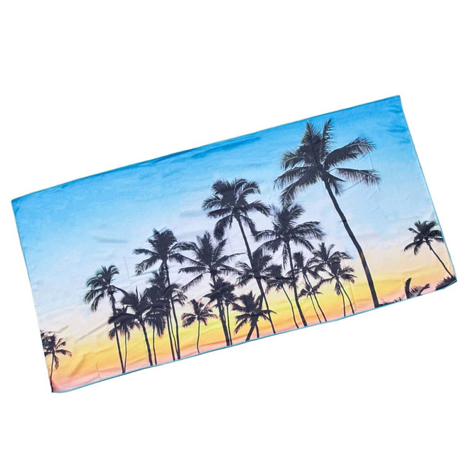 A beach towel in vibrant blue, featuring palm trees against a sunset backdrop. It has a logo in one corner.