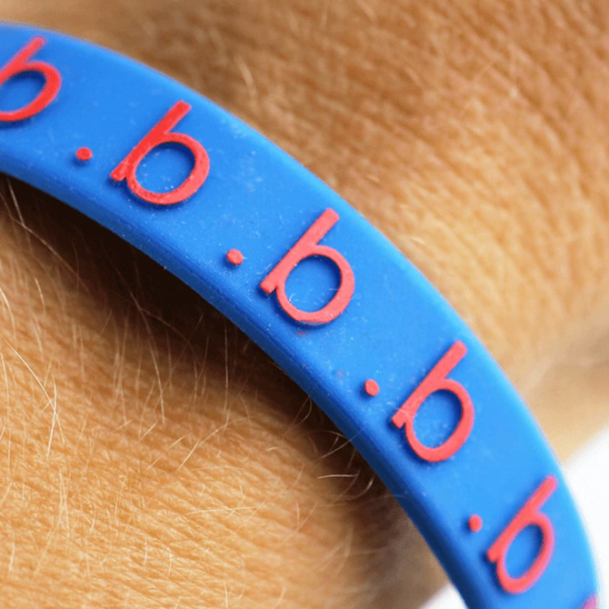 A blue silicone wristband with red embossed lettering, designed for exhibitions and events.