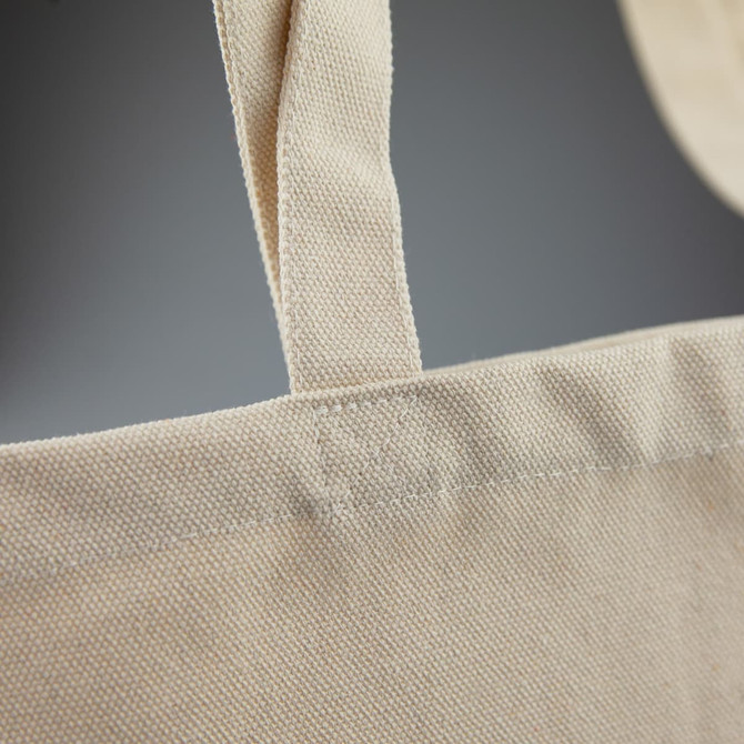 A light beige recycled cotton tote bag featuring sturdy shoulder straps and a simple design, with a branding logo.