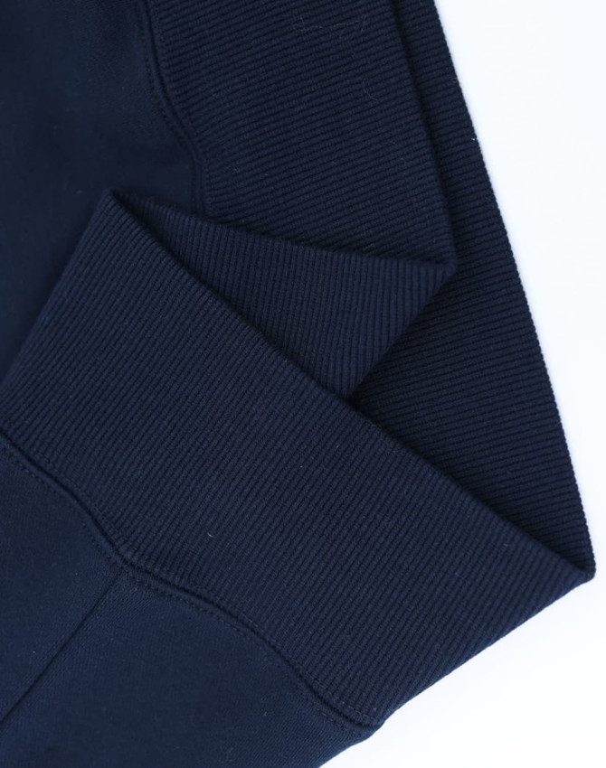 A close-up of the cuff detailing on a navy unisex premium fleece oversized hoodie, featuring a ribbed texture.
