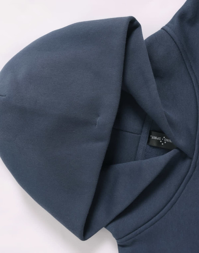 A navy blue oversized hoodie with a spacious hood and a label inside. The fabric appears soft and fleece-like.