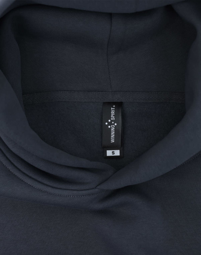 A dark grey oversized hoodie featuring an internal label and a hood design. Contains a branding logo.
