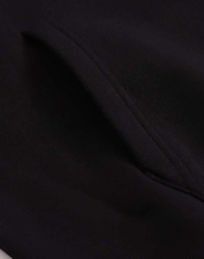 A close-up of a black unisex premium fleece oversized hoodie, highlighting the fabric texture and stitching details.