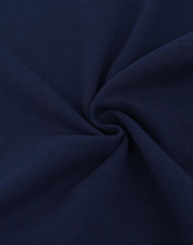 A close-up view of dark navy cotton/poly pique fabric, showcasing its texture and weave.