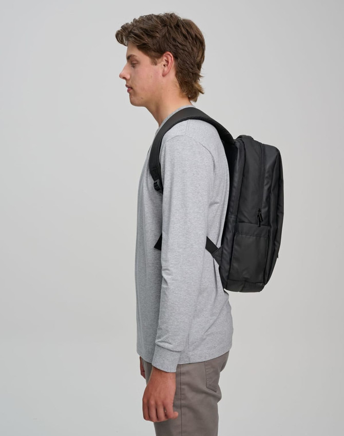 A black Elite PU backpack is shown worn on the back of a person in a grey long-sleeve shirt.