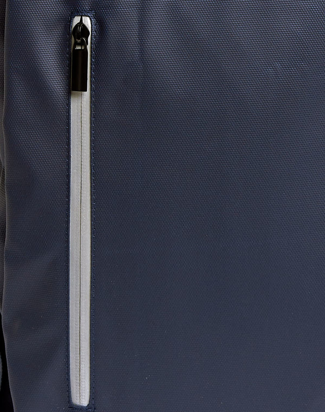 A navy backpack with a white zip pocket on the side, featuring a sleek design and a logo.