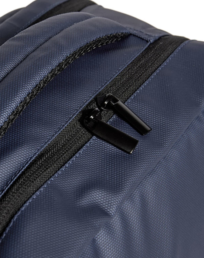 A navy blue backpack features black zippers and a textured fabric. It has a simple design with no visible logos.