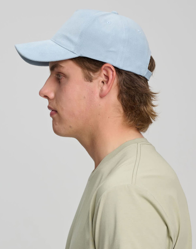 A light blue Jacquard Texture 5 Panel Cap shown on a model's head, featuring a branding logo on the side.