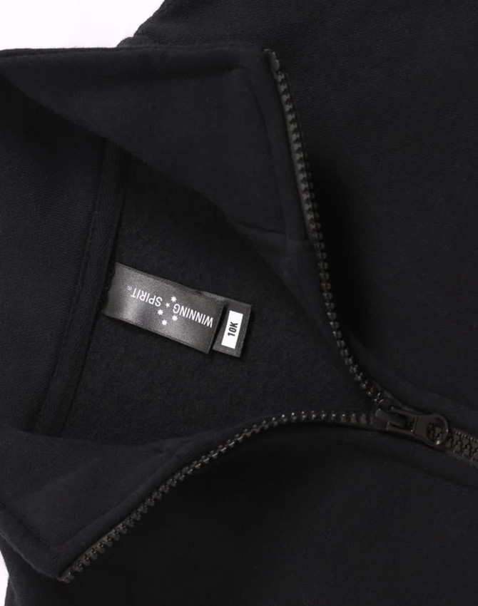 A black fleecy sweatshirt featuring a half zip collar, with an inner label and a subtle logo.