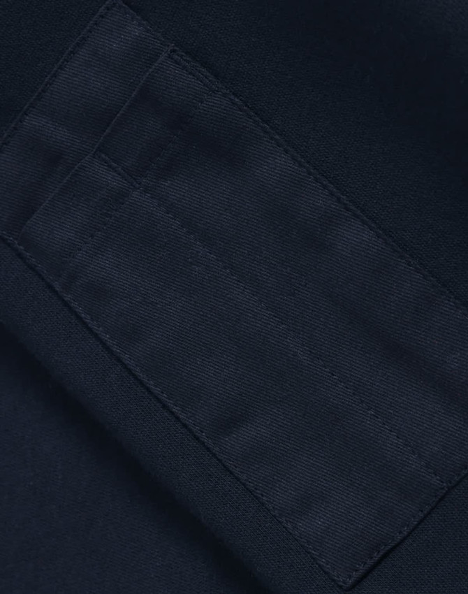 A close-up of a navy fleece fabric with a textured patch, featuring an area for branding or labels.