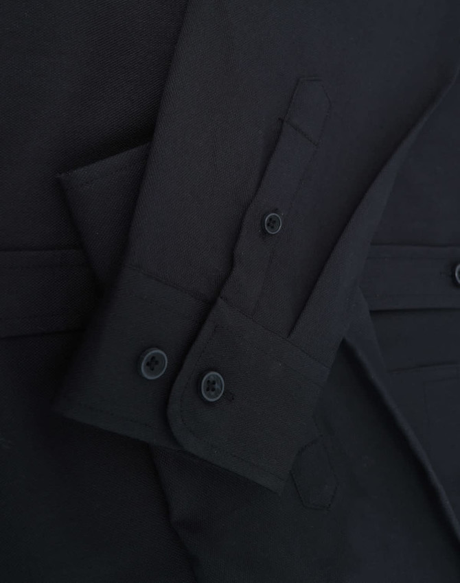 A black ladies' shirt featuring long sleeves and button details, showcasing a cotton blend fabric.