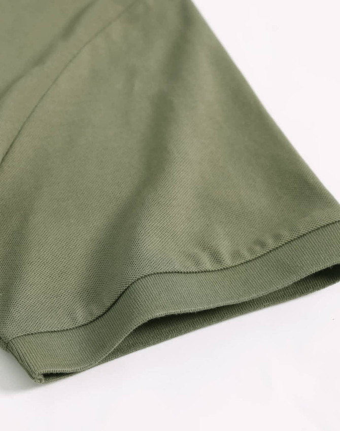 A close-up of a khaki green ultrafine cotton pique polo shirt, featuring a hem and sleeve detail.