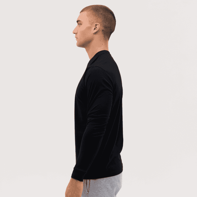 A long sleeve tee in black, featured on a model in profile view, showcasing a simple and sleek design.