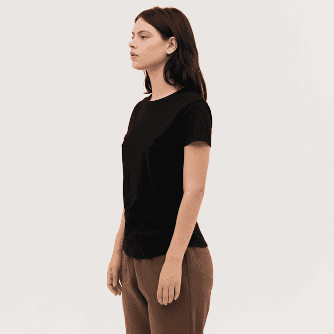 A black women's essential tee is displayed on a model, showcasing a simple, fitted design.