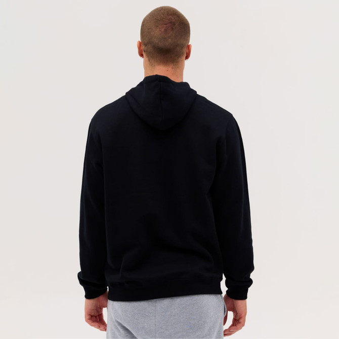 A black hoodie with a kangaroo pocket seen from the back, worn by a person in grey sweatpants.