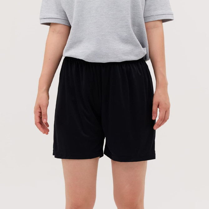Black shorts displayed on a person, paired with a grey shirt, featuring an elastic waistband.