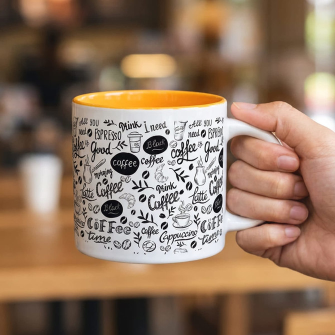 A coffee mug with a vibrant orange interior, decorated with various coffee-related designs and a branding logo.
