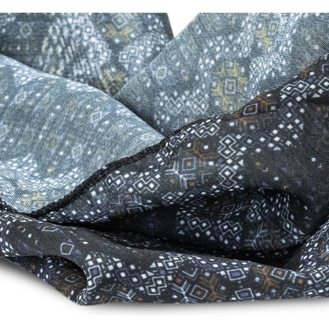 A patterned fabric headband in shades of blue and black, featuring geometric designs. It has a soft texture.