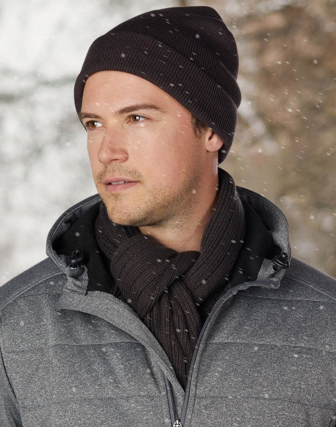 A red acrylic beanie with a ribbed texture and a rolled brim. It features a branding logo.